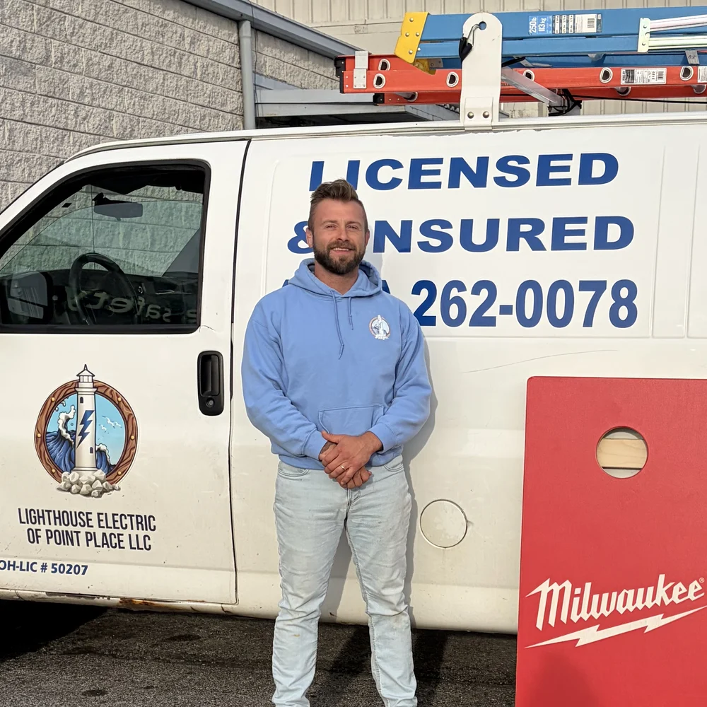 Casey Grup, owner of Lighthouse Electric of Point Place, in front of the company service van